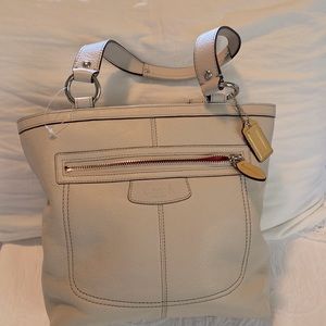 Light beige coach tote bag. Barbie pink on the inside with multiple pockets.